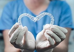 Dentist holding out Invisalign in heart shape