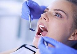 dentist examining a young woman’s mouth 