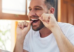 Man flossing his teeth