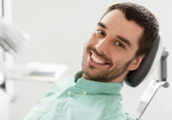 Man sitting back in dental chair and smiling