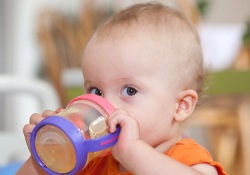 A little baby drinking from a sippy cup