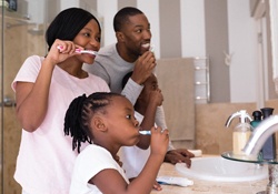 A family brushing their teeth at home together
