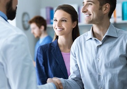 Smiling man shaking hands with cosmetic dentist in New Lenox