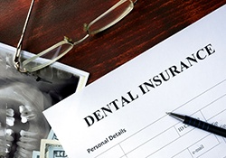 A dental insurance form on a wooden table