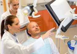 A dentist discussing with a patient what is on a screen