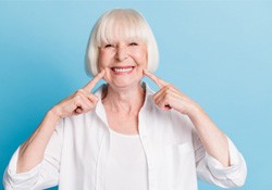 Woman pointing to her smile