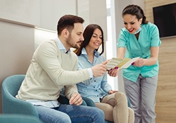 dental team member showing brochure to patients