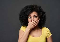 Woman with a toothache in New Lenox covering her mouth