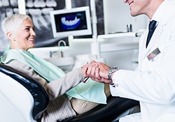 Implant dentist in New Lenox holding a patient’s hand