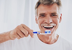 man brushing his teeth 