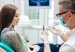 dentist showing a dental implant to a patient