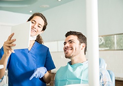 Dentist showing patient image on tablet