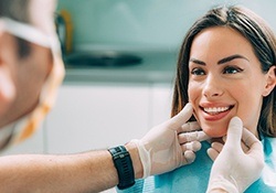 A dentist examining a female patient’s smile to recommend appropriate cosmetic treatment