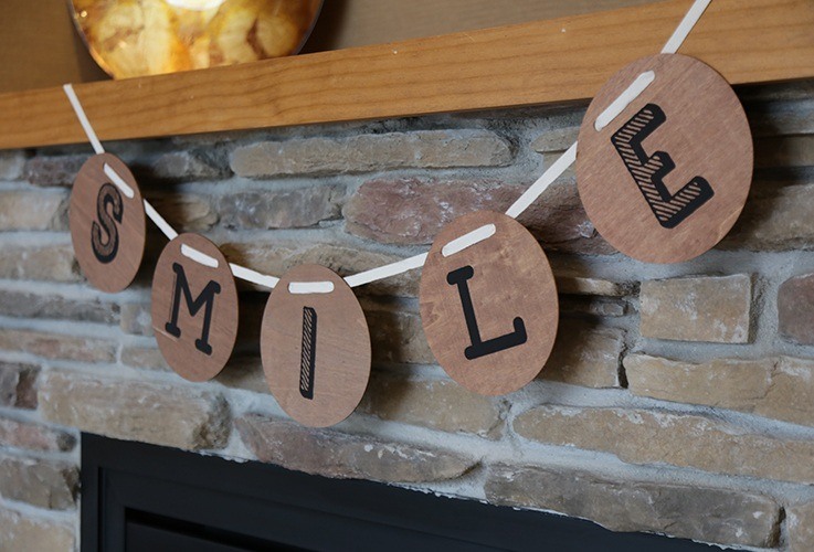 Garland above fireplace spelling out smile