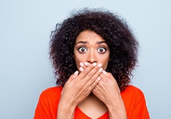 woman nervously covering her mouth 