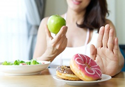 woman choosing to eat apples instead of donuts