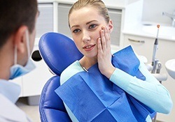Woman holding cheek in pain