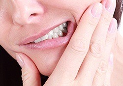 Closeup of patient holding jaw in pain