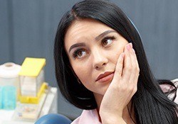 Woman holding cheek in pain