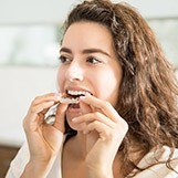 Woman placing Invisalign tray