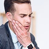 Man holding jaw in pain