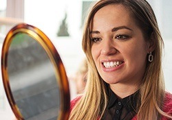 Woman looking at her smile in a mirror