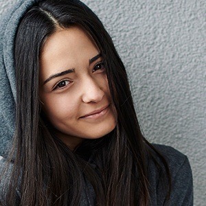 Young woman hiding teeth when she smiles