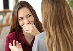 Laughing woman covering mouth