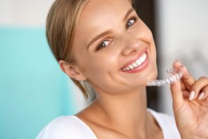 Woman holding clear aligning tray