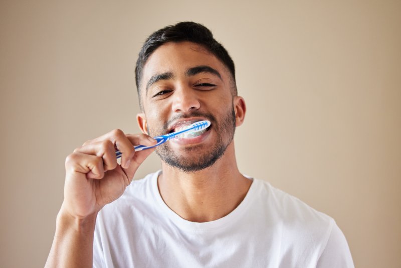 man brushing his teeth in New Lenox