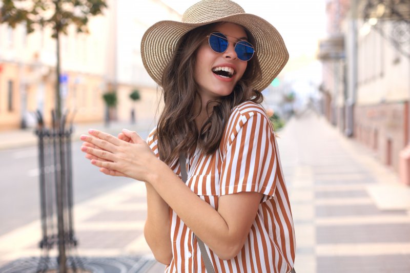 Woman smiling during summer after visiting a cosmetic dentist