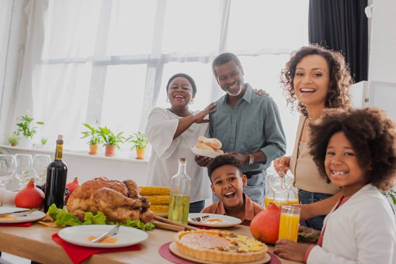 A family enjoying Thanksgiving and smiling with good oral health